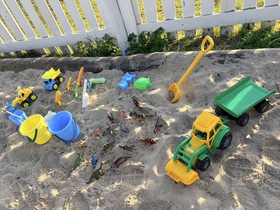 A young child enjoying outdoor sand play